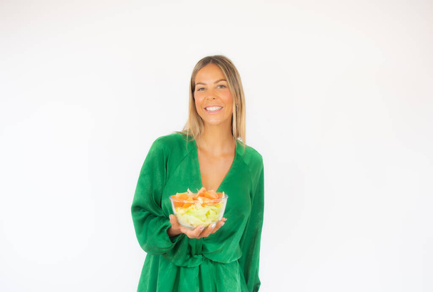 Gyönyörű nő zöld ruhában, saláta mosollyal. - Fotó, kép