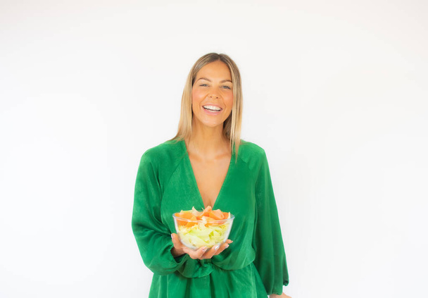 Belle femme en robe verte avec une salade souriante - Photo, image