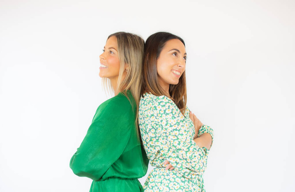 Two friends in green dresses pose together smiling - Fotó, kép