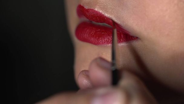 Close up truccatore fare make-up professionale per la giovane donna in studio di bellezza. Trucco Artista applicando rossetto sul modello - Foto, immagini