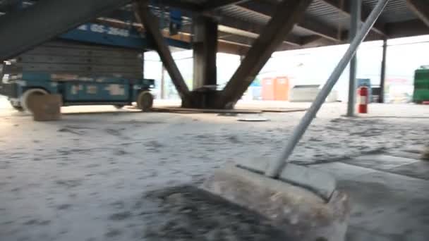 Low drifting shot of man scraping cement off floor. - Footage, Video