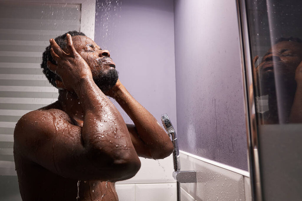 good looking man wet taking shower in bath - Foto, afbeelding