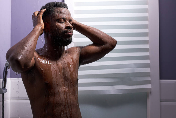 black man washing head with shampoo in shower - Фото, изображение