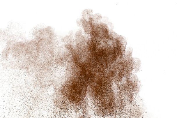 Bruin stof exploderende wolk.Bruine deeltjes spatten op witte achtergrond. - Foto, afbeelding