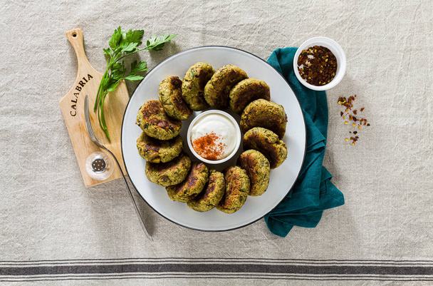delicious vegan eggplant cutlets with yogurt and hot pepper sauce, cuisine of the Calabria region in Italy on a linen tablecloth on the table - Photo, image