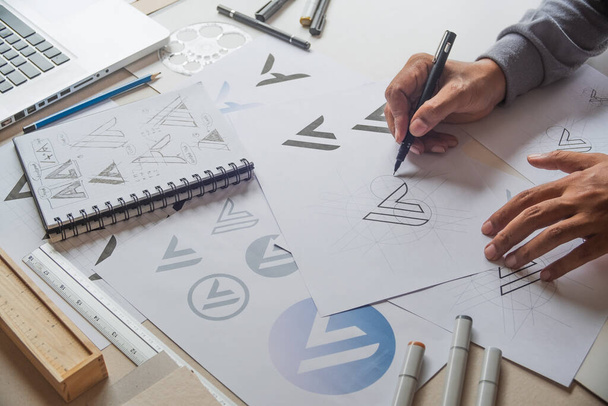 Graphic designer drawing sketch design creative Ideas draft Logo product trademark label brand artwork. Graphic designer studio Concept. - Photo, Image