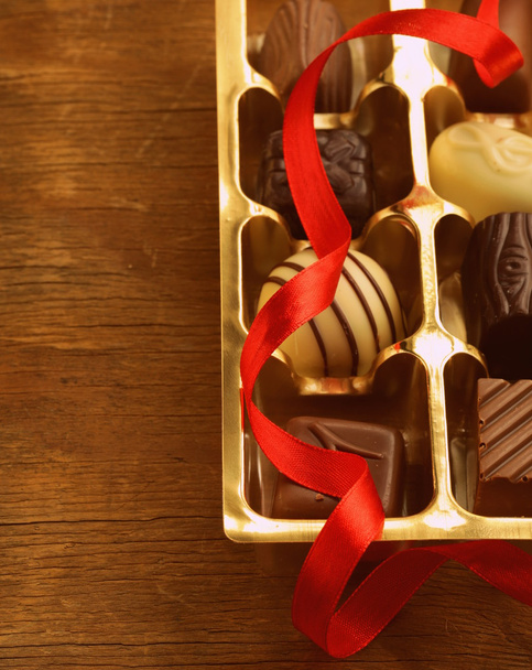 Caixa de presente de doces de chocolate em um fundo de madeira, tonificada em estilo retro
 - Foto, Imagem