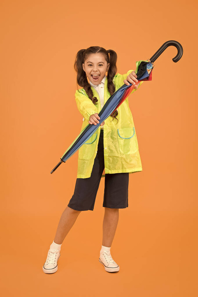 Small schoolgirl wear water resistant clothes for rainy day. Cute schoolgirl feel protected for spring weather. Waterproof concept. Match your raincoat with umbrella. Schoolgirl wear raincoat - Fotó, kép