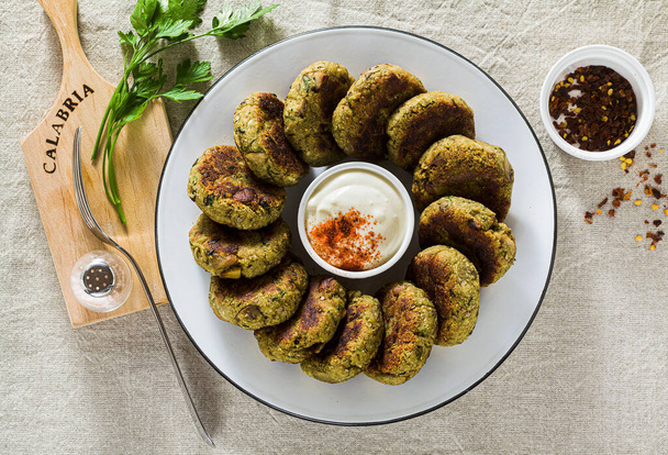 delicious vegan eggplant cutlets with yogurt and hot pepper sauce, cuisine of the Calabria region in Italy on a linen tablecloth on the table - Foto, imagen