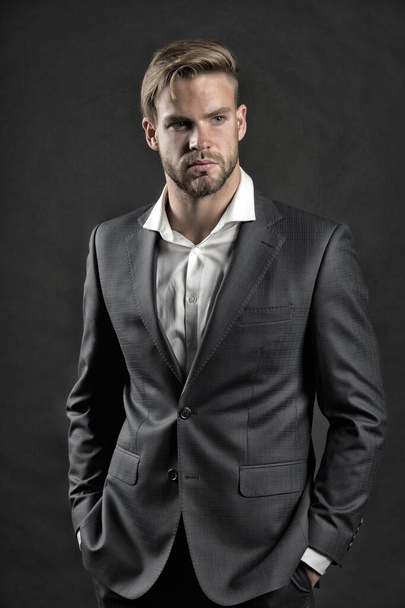 Businessman attractive cares about appearance. Man bearded strict face with hairstyle, dark background. Masculinity concept. Man bearded unshaven guy looks handsome well groomed in formal wear - Fotografie, Obrázek