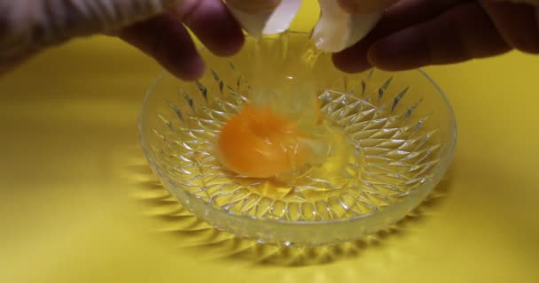 Les mains cassent les œufs et les mettent dans un bol en verre - Séquence, vidéo
