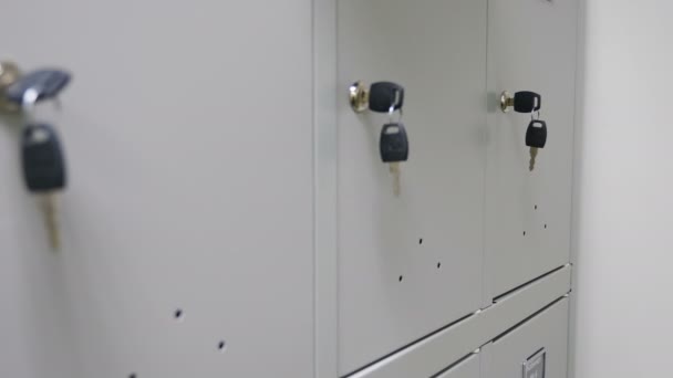 Pequeños casilleros de seguridad con llaves. Llave de primer plano en las cerraduras en el vestuario del gimnasio o sala de personal. concepto de caja de seguridad de seguridad de metal. 4 k imágenes - Metraje, vídeo