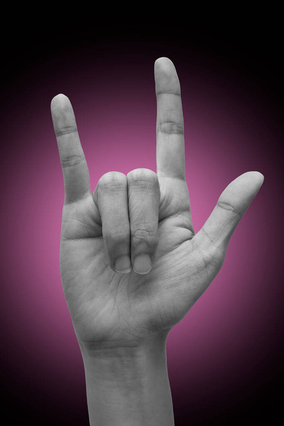Mano de mujer haciendo lenguaje de señas "Te amo". aislado en el fondo del gradiente. Signo de metal. Concepto de comunicación.  - Foto, Imagen