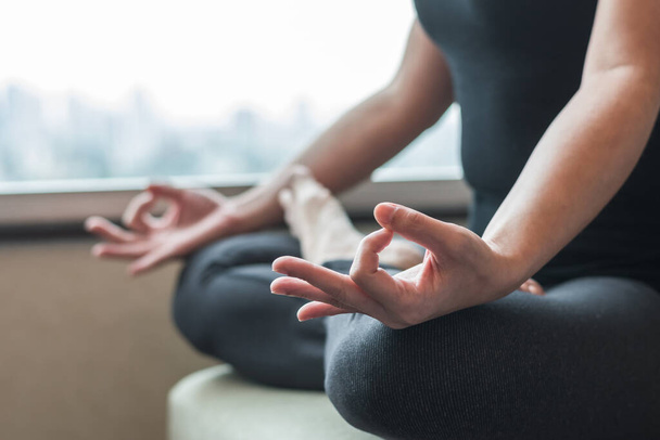 Menselijke geest meditatie therapie, metalen balans concept met vrouw persoon in yoga lotus poseren met spirituele meditatie, ontspannen in stilte in gymles of huis indoor in de ochtend - Foto, afbeelding