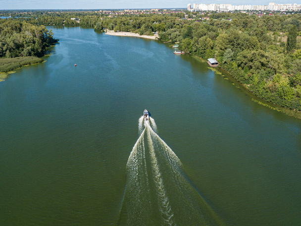 Motorcsónak a Dnipro folyóban. Napfényes, tiszta nyári nap. Légi drónra néző. - Fotó, kép