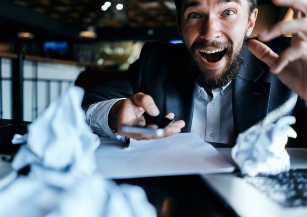 liikemies istuu pöydässä edessä kannettava tietokone rypistynyt paperi elämäntapa johtaja työteknologia - Valokuva, kuva
