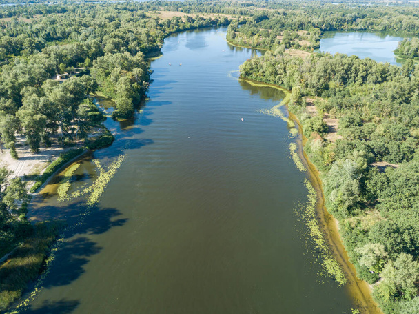 A Dnyeper folyó zöld partja egy nyári napsütéses napon. Légi drónra néző. - Fotó, kép