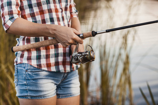 Fishing with rod on lake. womans hand with spinning - Fotoğraf, Görsel