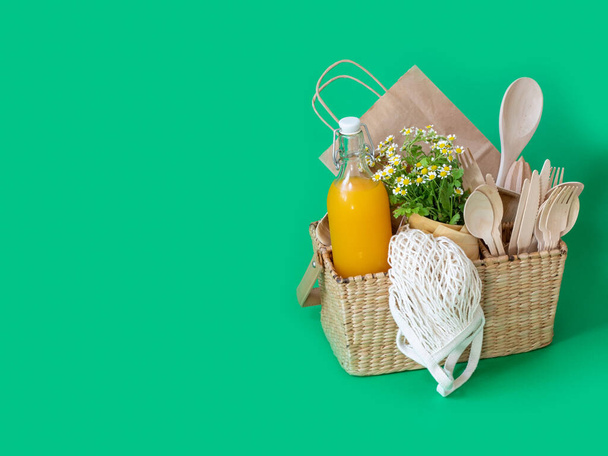 Basket with wooden things on a colored background. Ecological concept. Zero waste. - Фото, зображення