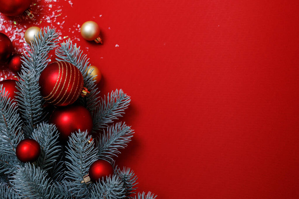 Fondo navideño en rojo y verde. Composición decorativa festiva: Árbol de Navidad, bolas grandes y pequeñas de rojo y oro, nieve artificial. Vista superior. A nadie. Horizontal, lugar para el texto. Tema Feliz Año Nuevo - Foto, Imagen