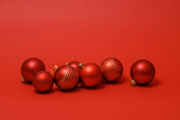 冬休みのコンセプト。赤い背景に赤いクリスマスボール。祭りのカードだ。レイアウトのための幸せな新年のテーマ。テキスト用のスペース。水平 - 写真・画像