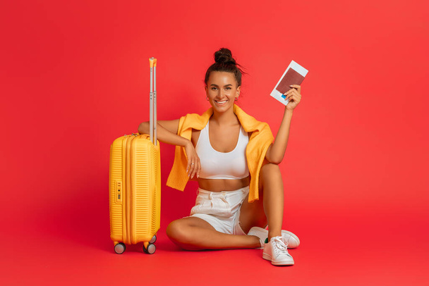Go on an adventure! Happy woman going traveling. Young person with suitcase on color background. - Fotografie, Obrázek
