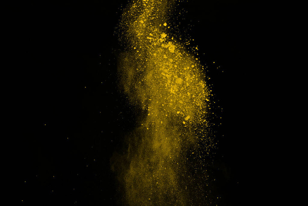 Freeze motion of yellow dust explosion isolated on black background. - Fotó, kép