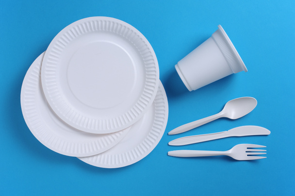 Jednorázové nádobí a příbory na modrém pozadí, pohled shora - Fotografie, Obrázek