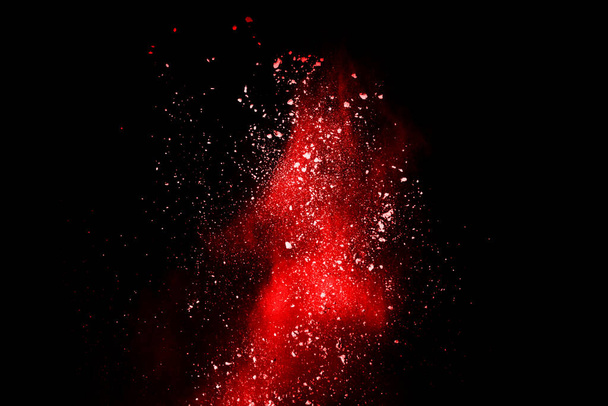 abstract rood poeder explosie op zwarte achtergrond.abstract rood poeder gespetterd op zwarte achtergrond. Bevriezen beweging van rood poeder exploderen. - Foto, afbeelding