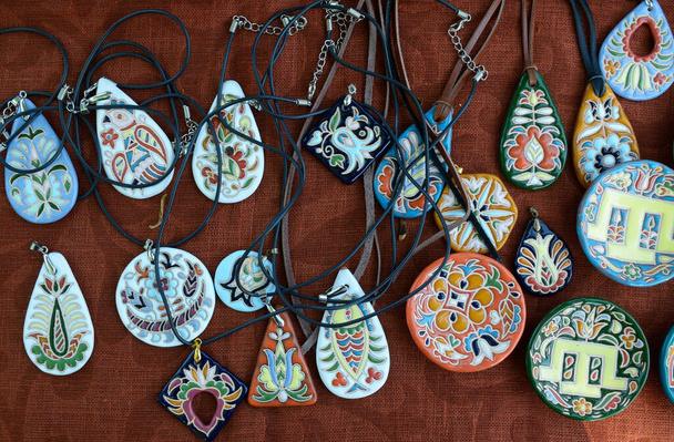 Traditionelle krimtatarische Keramik, Malerei: Schmuckstücke, Amulette und Anhänger auf einer Tischdecke - Foto, Bild