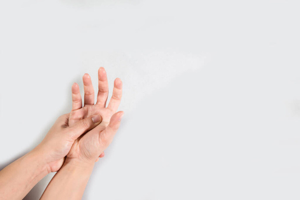 Young beautiful woman has pains in a hand. The hand hurts a woman isolated on white background. Close up Woman holding her hand, pain concept, Office Syndrome. - Foto, Imagem