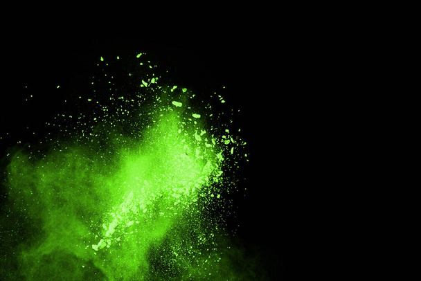 抽象的な塵爆発の動きは黒を背景に緑色に凍結した。黒の背景に粉末グリーンの動きを停止します。黒の背景に爆発性粉末緑. - 写真・画像