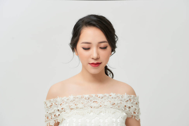 Beautiful bride with stylish makeup in white dress - Fotó, kép