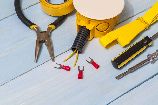 Repuestos y herramientas amarillas en tableros azules para eléctricos preparados antes de la reparación o ajuste - Foto, imagen