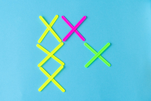 figures from counting sticks in the form of crosses on a blue background - Fotó, kép
