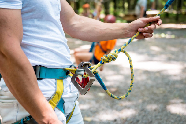 Young man in adventure rope park. Climbing Equipment. - Foto, Bild