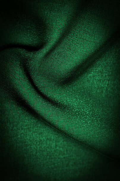 Hintergrundtextur Dunkelgrüne Chiffonseide ist ein weiches transparentes Gewebe mit einer leichten Rauheit (matt, gekreppt) aufgrund der Verwendung von gedrehtem Garn. - Foto, Bild