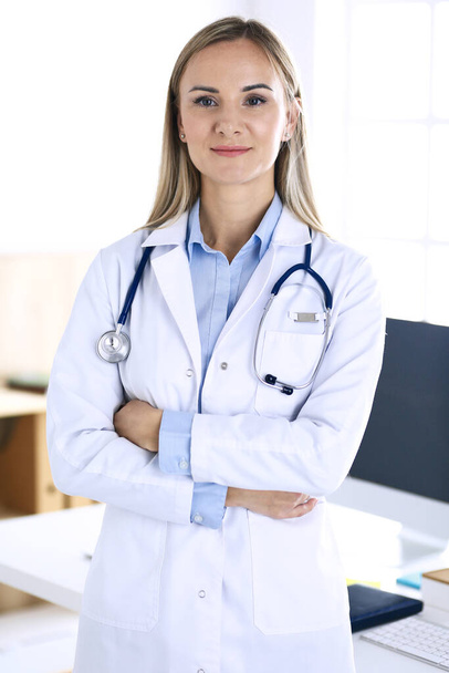 Woman doctor standing in hospital office. Physician at work, life portrait. Medicine and health care concept - Foto, Bild