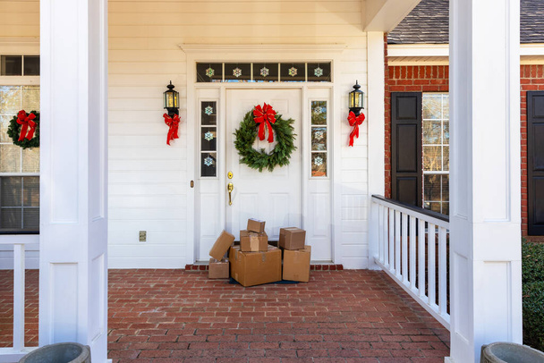 Pacchetti sul portico anteriore di casa durante le vacanze natalizie - Foto, immagini