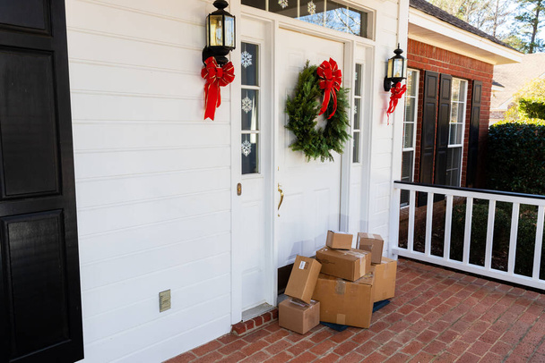Pacchetti sul portico anteriore di casa durante le vacanze natalizie - Foto, immagini