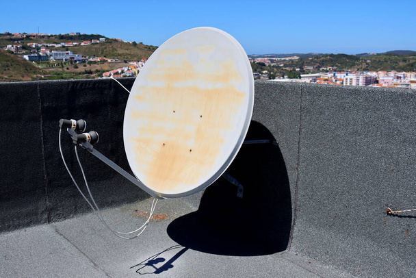 Parabolinen satelliittiantenni talon katolla. Vanha valkoinen televisio satelliittiantennit päivänvalossa - Valokuva, kuva