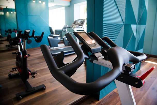 Intérieur moderne de la salle de gym avec équipement. Sonnettes, haltères, tapis roulants, équipement cardio - Photo, image