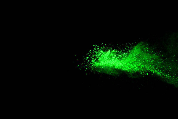 The movement of abstract dust explosion frozen green on black background. Stop the movement of powdered green on black background. Explosive powder green on black background. - Fotografie, Obrázek