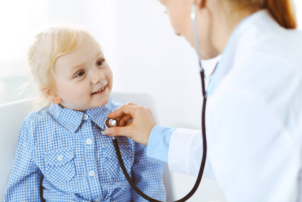 Happy smiling child patient at usual medical inspection. Doctor and patient in clinic. Medicine, healthcare concepts - 写真・画像