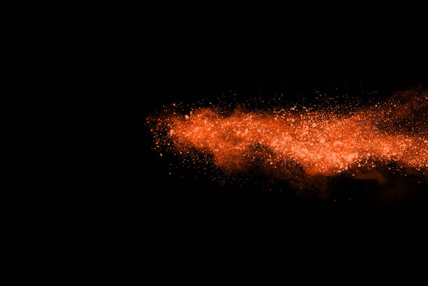 Movimento di congelamento della polvere arancione che esplode, isolata su sfondo nero. Design astratto della nube di polvere rossa. - Foto, immagini