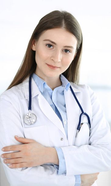 Doctor woman standing straight with arms crossed, portrait. Perfect medical service in clinic. Medicine and healthcare concepts - Fotoğraf, Görsel