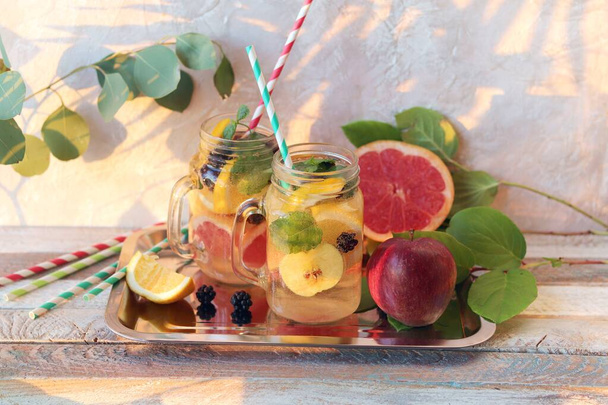 Erfrischendes Getränk, natürlicher Cocktail aus biologischen Früchten und Beeren, Minze in Glasbechern auf einem Holztisch, gesunde Ernährung, Hausmannskost - Foto, Bild