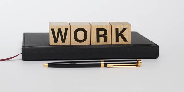 Work word made with building blocks with diary and pen isolated on white background. Concept work from home. Or job offer concept - Фото, изображение