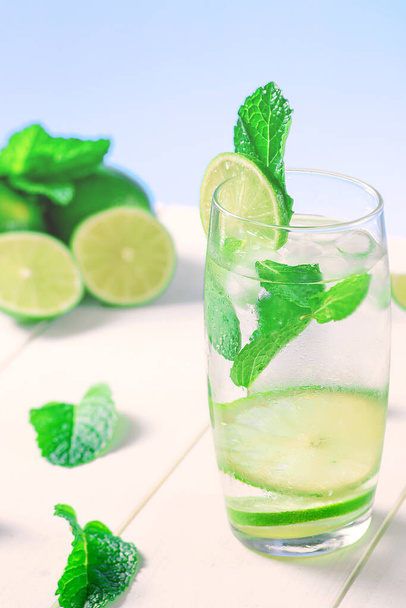 High glass of a drink with lime, ice cubes and mint for the summer - Photo, Image