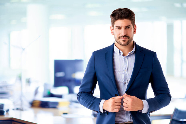 Portrait of handsome businessman wearing shirt and blazer while standing in the office.  - Fotografie, Obrázek